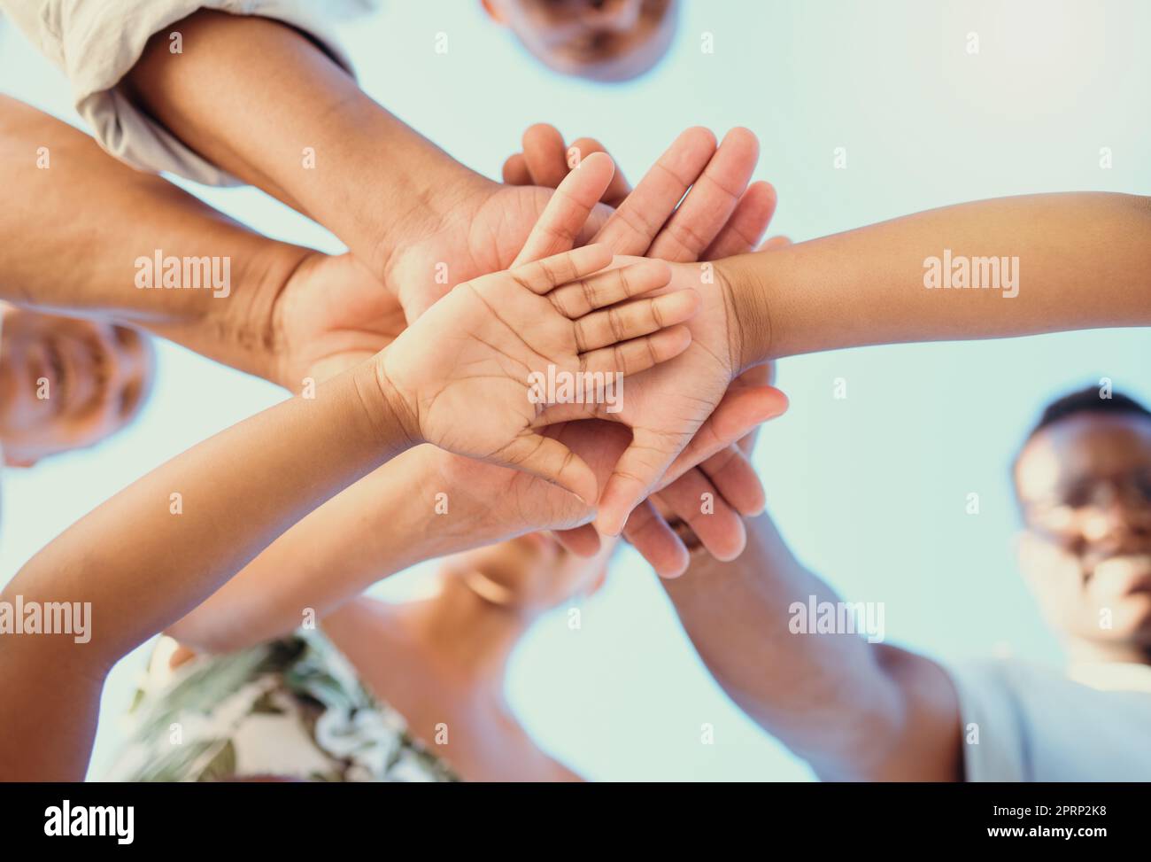 Unterstützung, Liebe und Familienhände im Freien vor dem Hintergrund des blauen Himmels. Die untenstehende Ansicht von Eltern und Kindern zeigt Einheit, Glauben und Vertrauen außerhalb der Natur Stockfoto