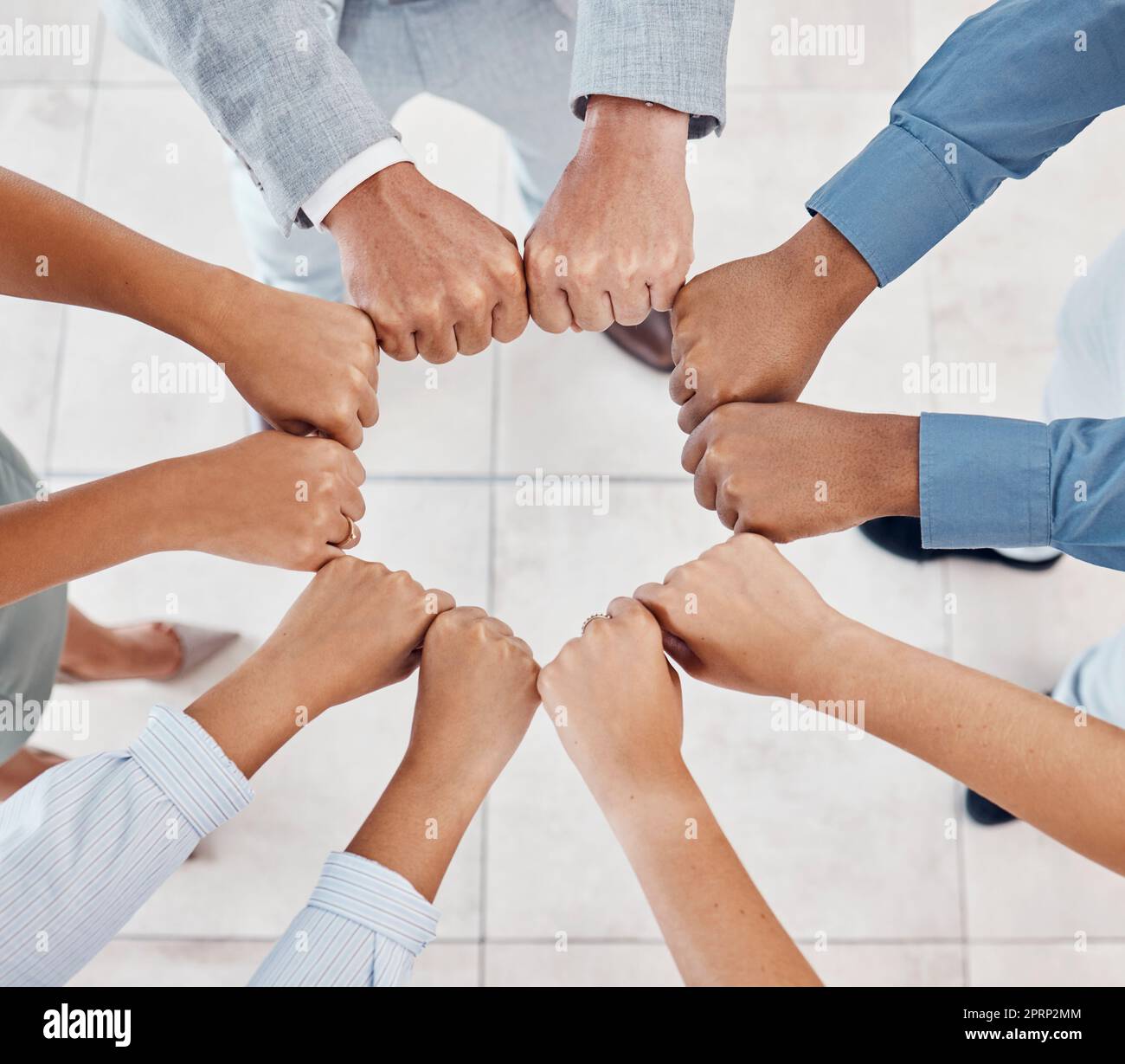 Fist of Diversity Business-Teams arbeiten in Partnerschaft, Zusammenarbeit und Teamwork in der Draufsicht zusammen. Hände von Geschäftsleuten bei Support-, Team-Building- und Strategiemeetings für globalen Unternehmenserfolg Stockfoto