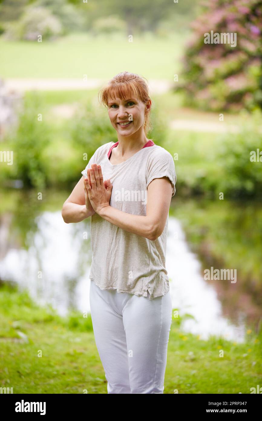 Frieden und Harmonie in der Natur finden. Eine Frau, die im Park Yoga macht. Stockfoto