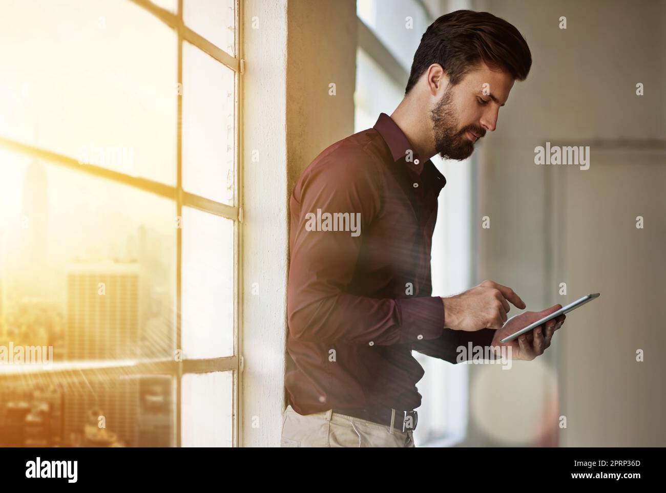 Einfacher Zugriff auf alle seine Informationen. Ein Geschäftsmann, der in seinem Büro ein digitales Tablet benutzt. Stockfoto