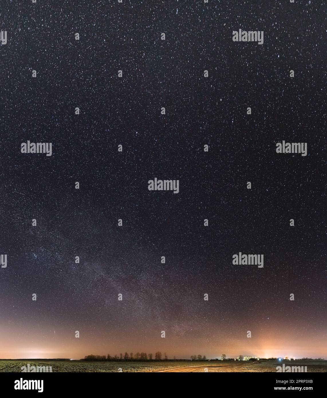 Nächtlicher Sternenhimmel Mit Leuchtenden Sternen Über Der Landschaft. Milky Way Galaxy Und Rural Field Meadow Im Frühling. Stockfoto