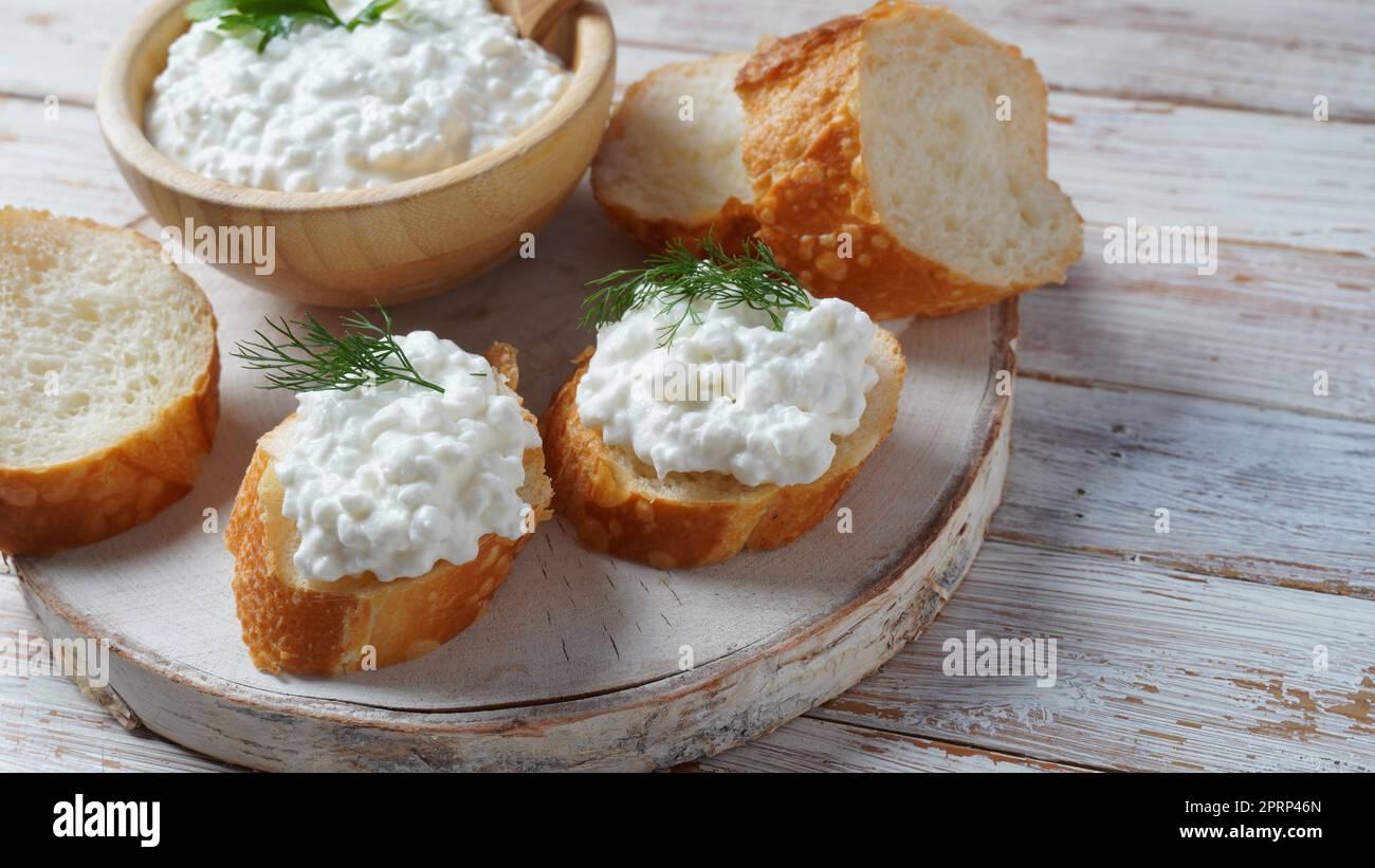 Hüttenkäse in einer Schüssel auf einem hölzernen Hintergrund. Diät und gesunde Ernährung Konzept Stockfoto