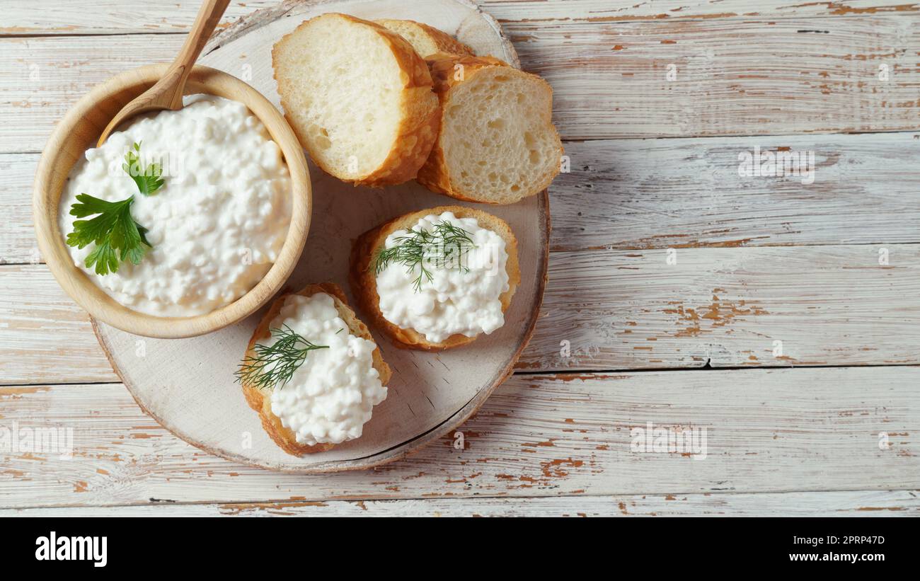 Hüttenkäse in einer Schüssel auf einem hölzernen Hintergrund. Diät und gesunde Ernährung Konzept Stockfoto