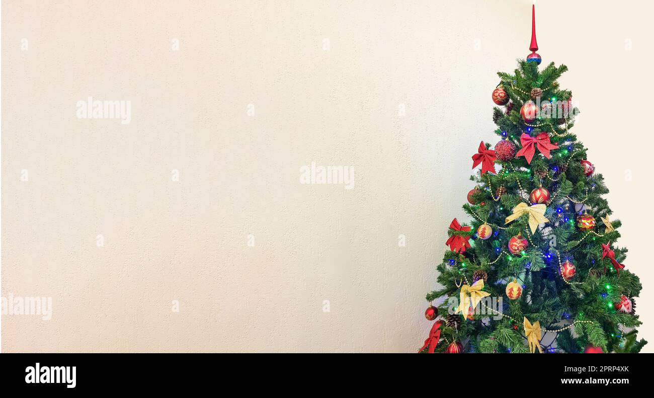 Ein festliches Foto eines Weihnachtsbaums mit bunten Verzierungen, hervorgehoben auf weißem Hintergrund mit einer Kopie des Bereichs auf der linken Seite Stockfoto