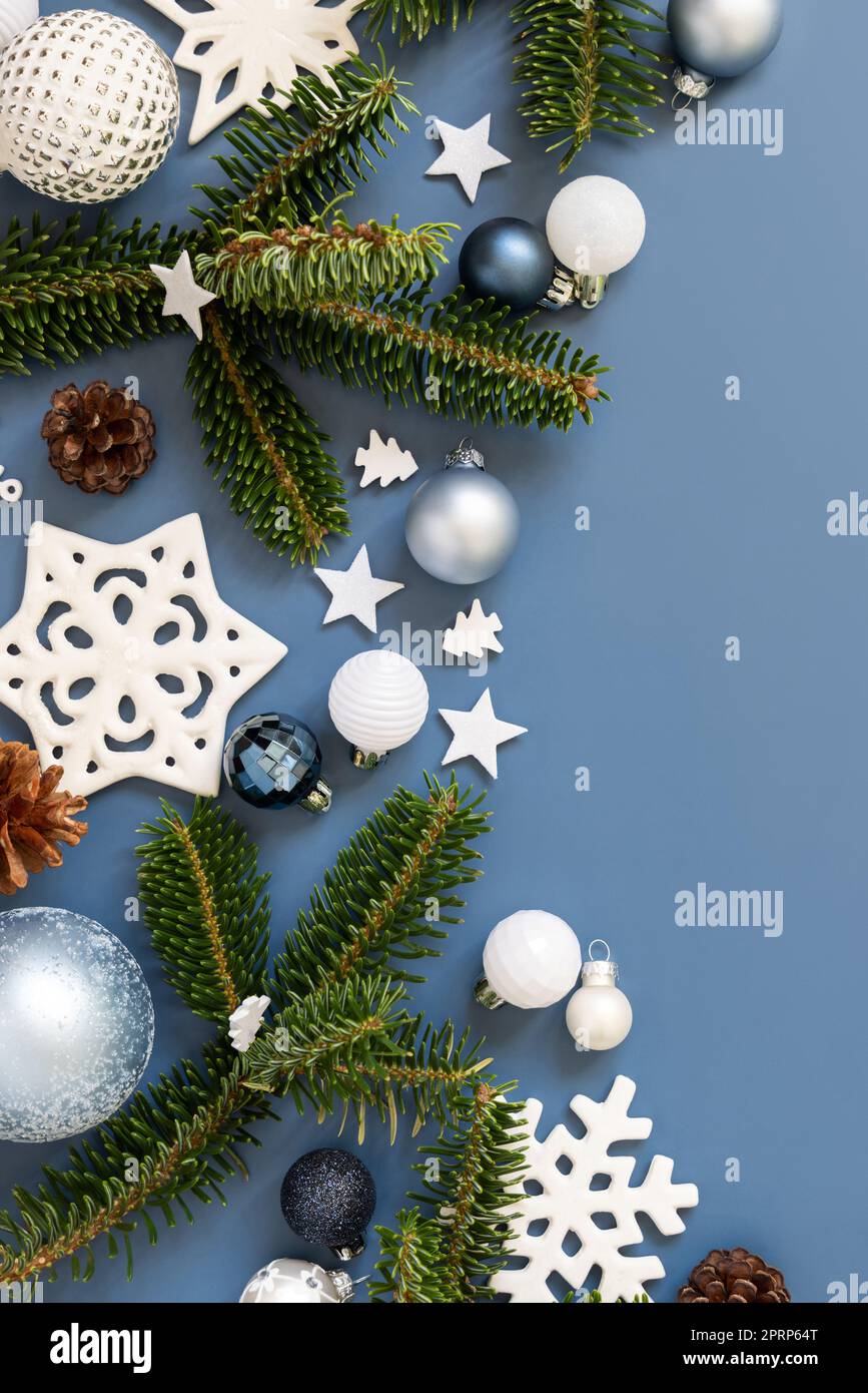 Weiße Weihnachtsdekorationen und Tannenzweige auf blauer Draufsicht mit Kopierbereich Stockfoto