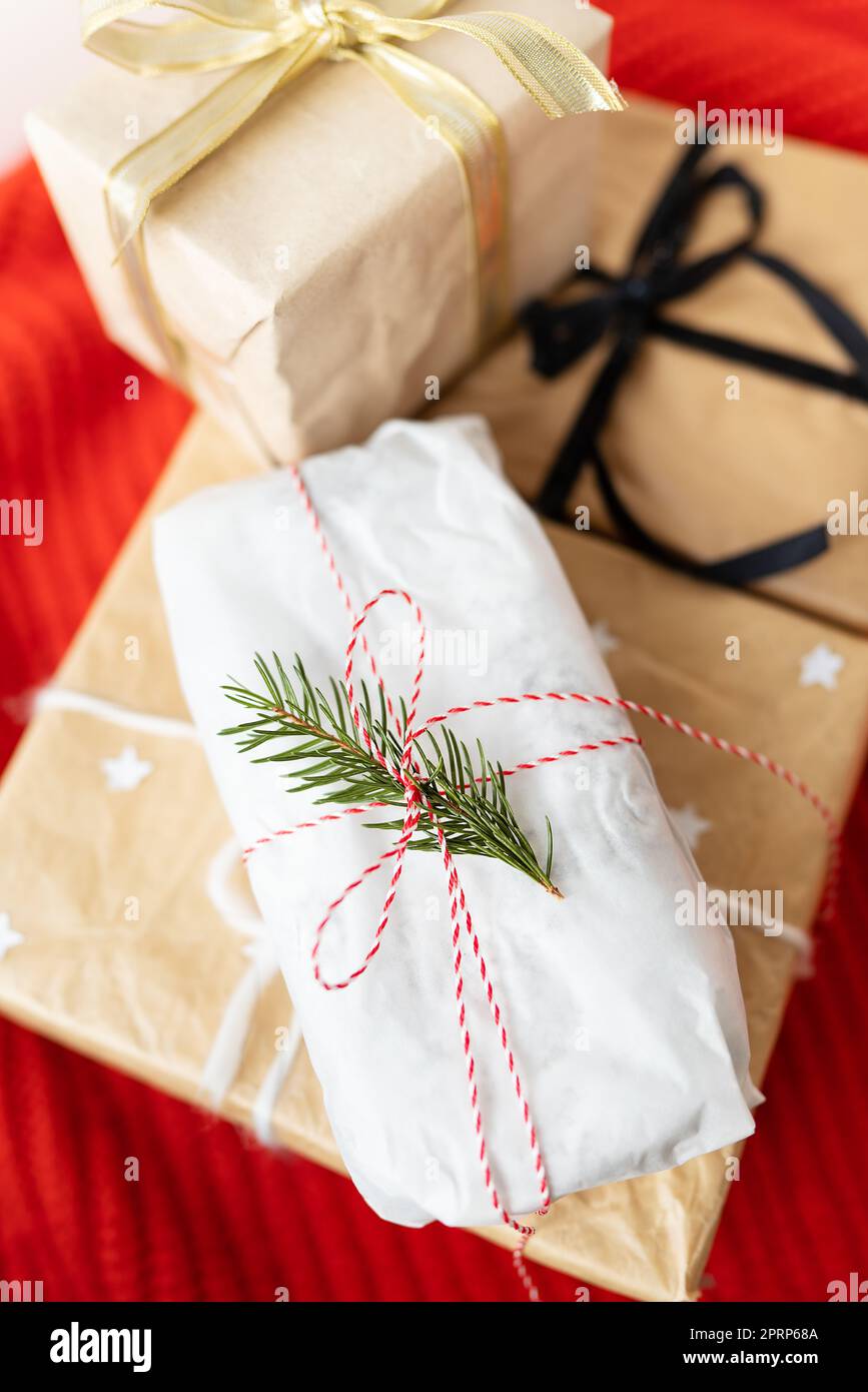 Geschenkschachteln oder Geschenke in Kraftpapier und wunderschönen Bändern verpackt. Das Konzept der Feiertage, Weihnachten, Neujahr 2023-2024. Stockfoto