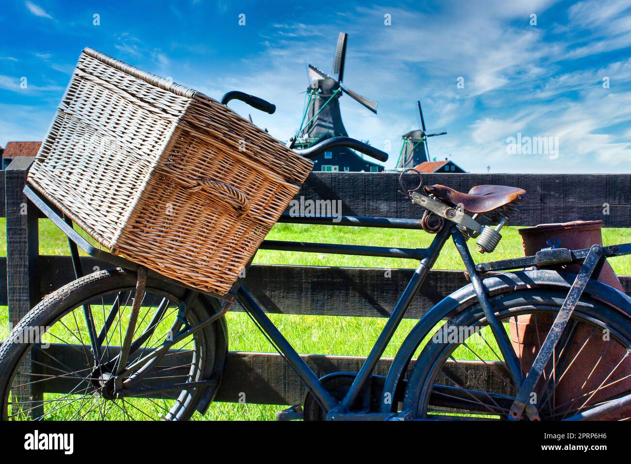 Fahrrad mit Windmühle und blauem Himmel Hintergrund. Landschaftlich reizvolle Landschaft in der Nähe von Amsterdam in den Niederlanden. Stockfoto