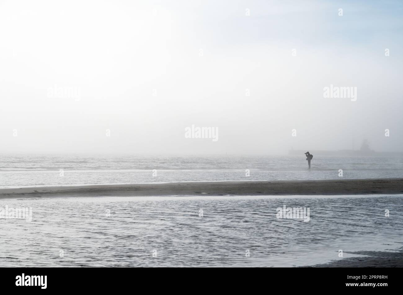Nebel an der Ostseeküste im Frühling. Moody Wetter, Nebel. Person, die in der Ferne steht Stockfoto