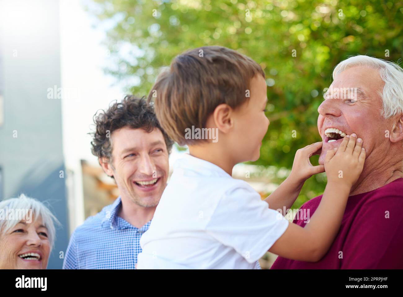 Mit Opa herumwirren. Eine Familie mit mehreren Generationen verbringt draußen Zeit miteinander. Stockfoto