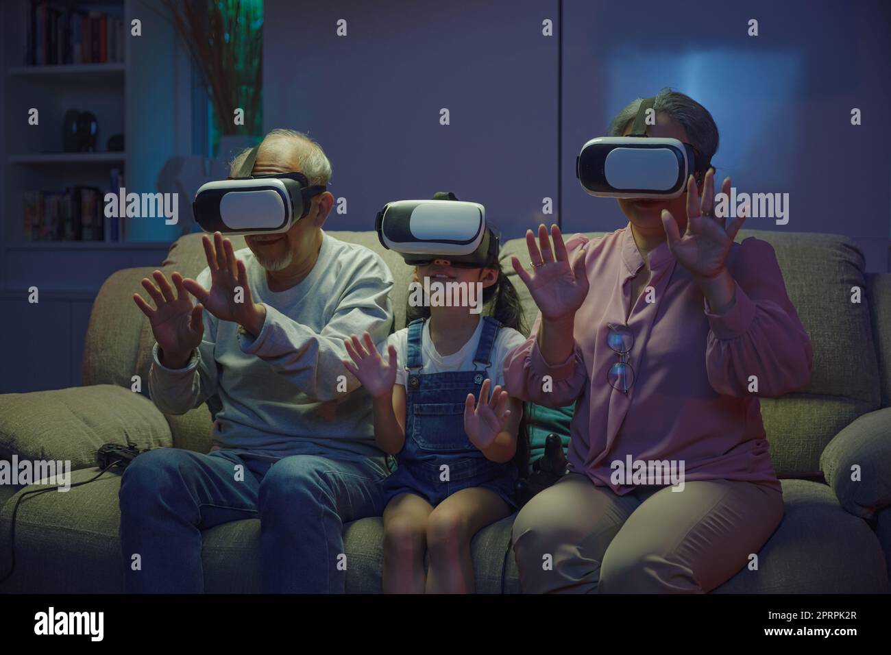 Asiatische Senioren mit Kind spielen VR-Videospiel Stockfoto