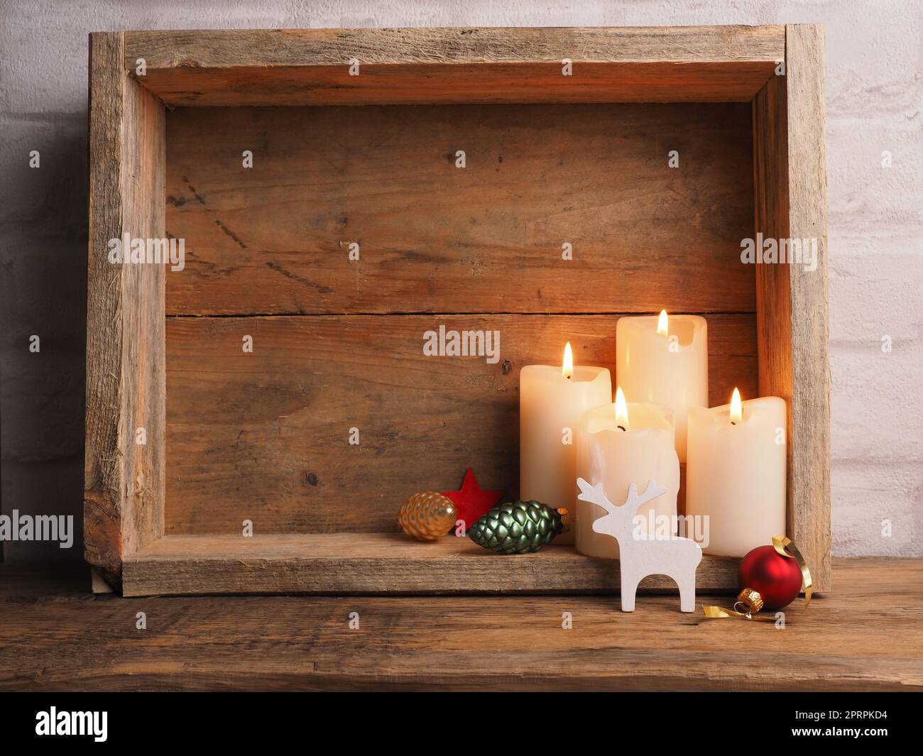 Weiße Adventskerzen in einer Holzkiste mit Weihnachtsdekoration Stockfoto