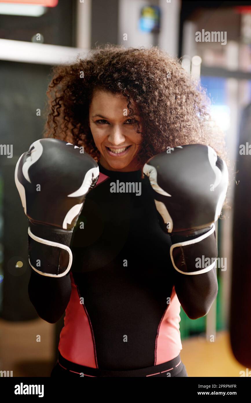 Du hast dein Spiel getroffen. Porträt einer jungen Frau, die beim Training Boxhandschuhe trägt. Stockfoto