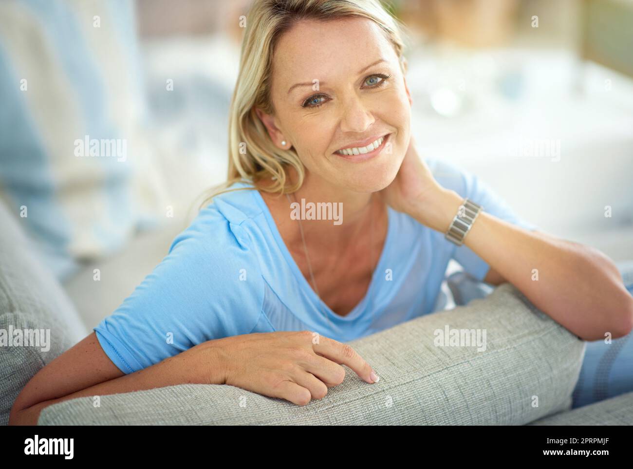Fühlt sich gut an, zu Hause zu sein. Porträt einer reifen Frau, die sich zu Hause auf dem Sofa entspannt. Stockfoto