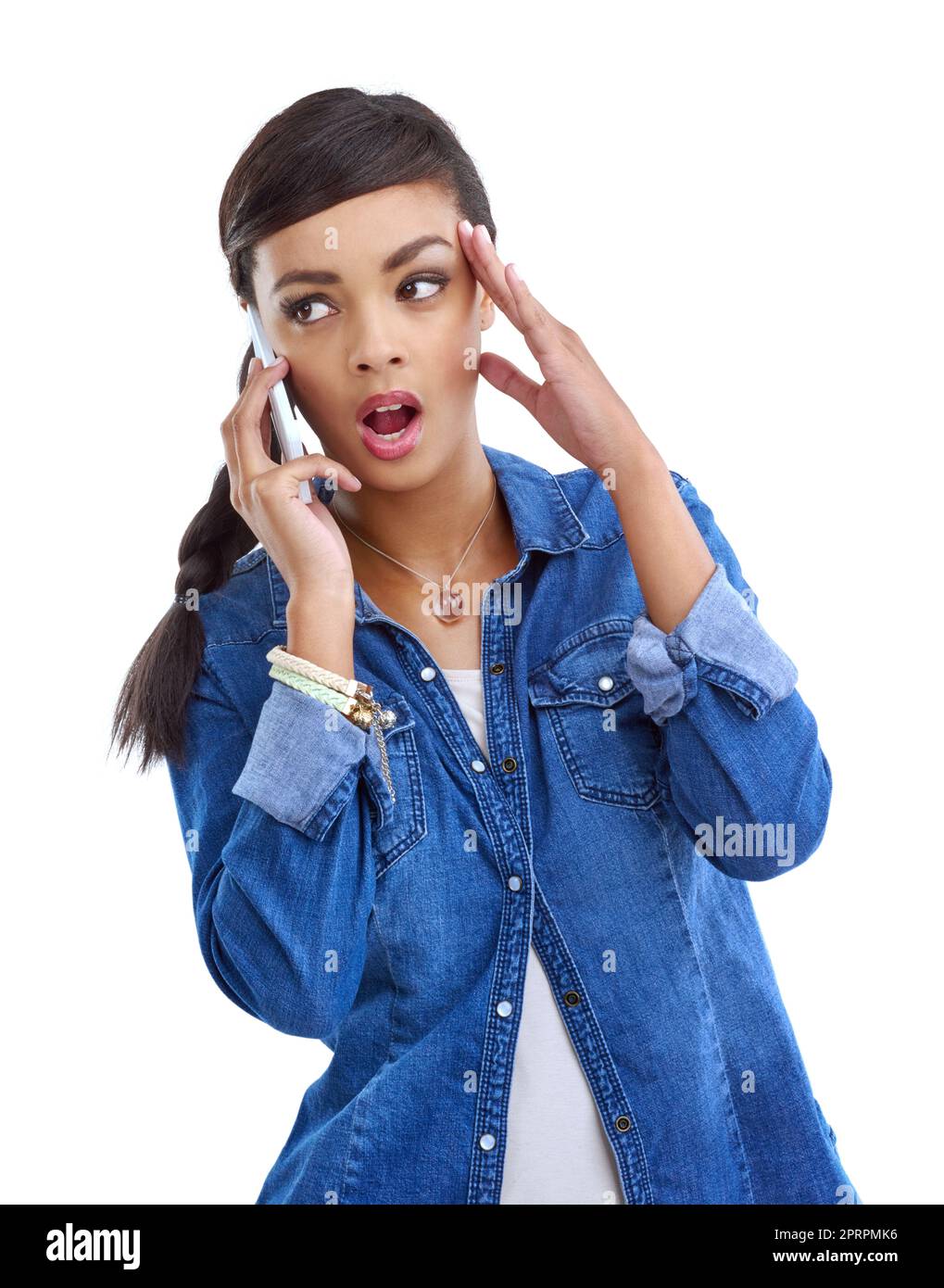 Sagen sie whaaaat. Studioaufnahme einer jungen Frau, die ihr auf Weiß isoliertes Handy benutzt. Stockfoto