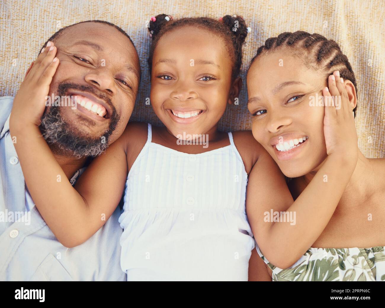 Liebe, Fürsorge und glückliche schwarze Familie verbindet, entspannen und erholen Sie sich zu Hause von oben. Porträt von lächelnden Eltern, die Zeit mit ihrem Kind genießen, Zuneigung zeigen und mit ihrer Tochter liebevoll sind Stockfoto