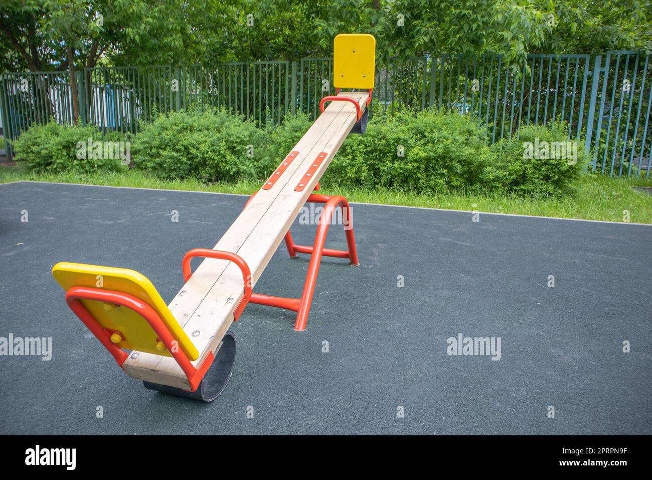 Balancierende Schaukel in Form eines Holzbretts auf einem leeren Spielplatz im Freien, Kinderspielplatz Stockfoto