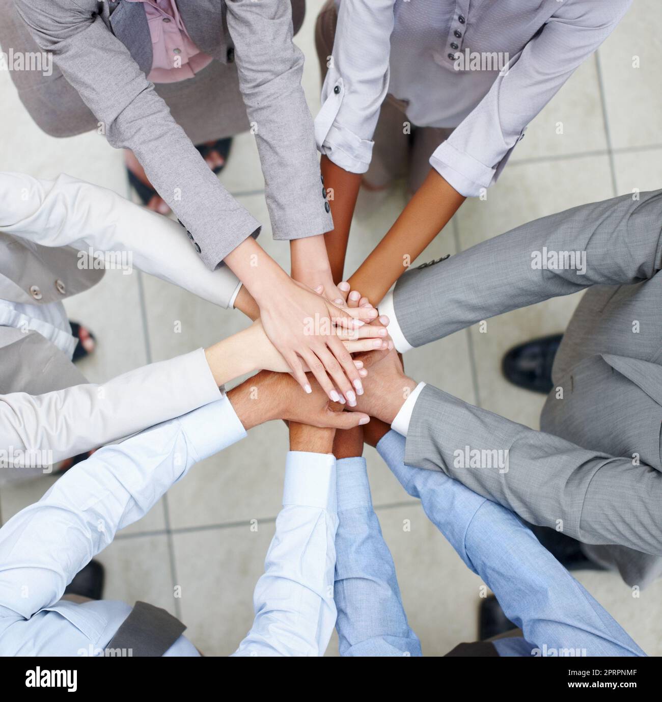 Team zusammenführen. Fusionierte Kollegen legen ihre Hände zusammen, um ihre Einheit zu feiern. Stockfoto