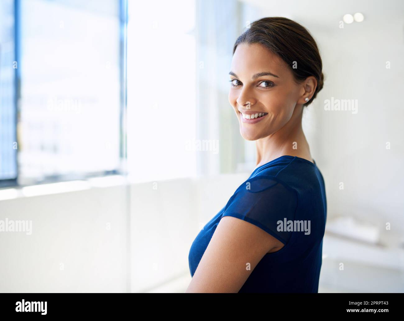 Glücklich in ihrer Karriere. Beschnittenes Porträt einer attraktiven jungen Geschäftsfrau im Büro. Stockfoto