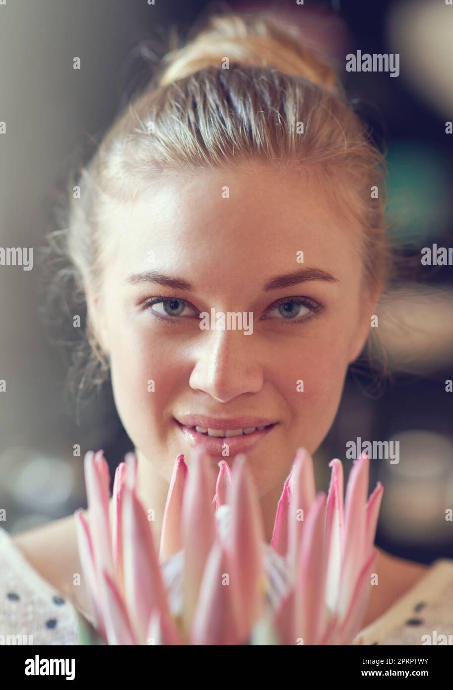 Weiche natürliche Schönheit. Nahaufnahme Porträt einer schönen jungen Frau, die drinnen eine protea-Blume hält. Stockfoto