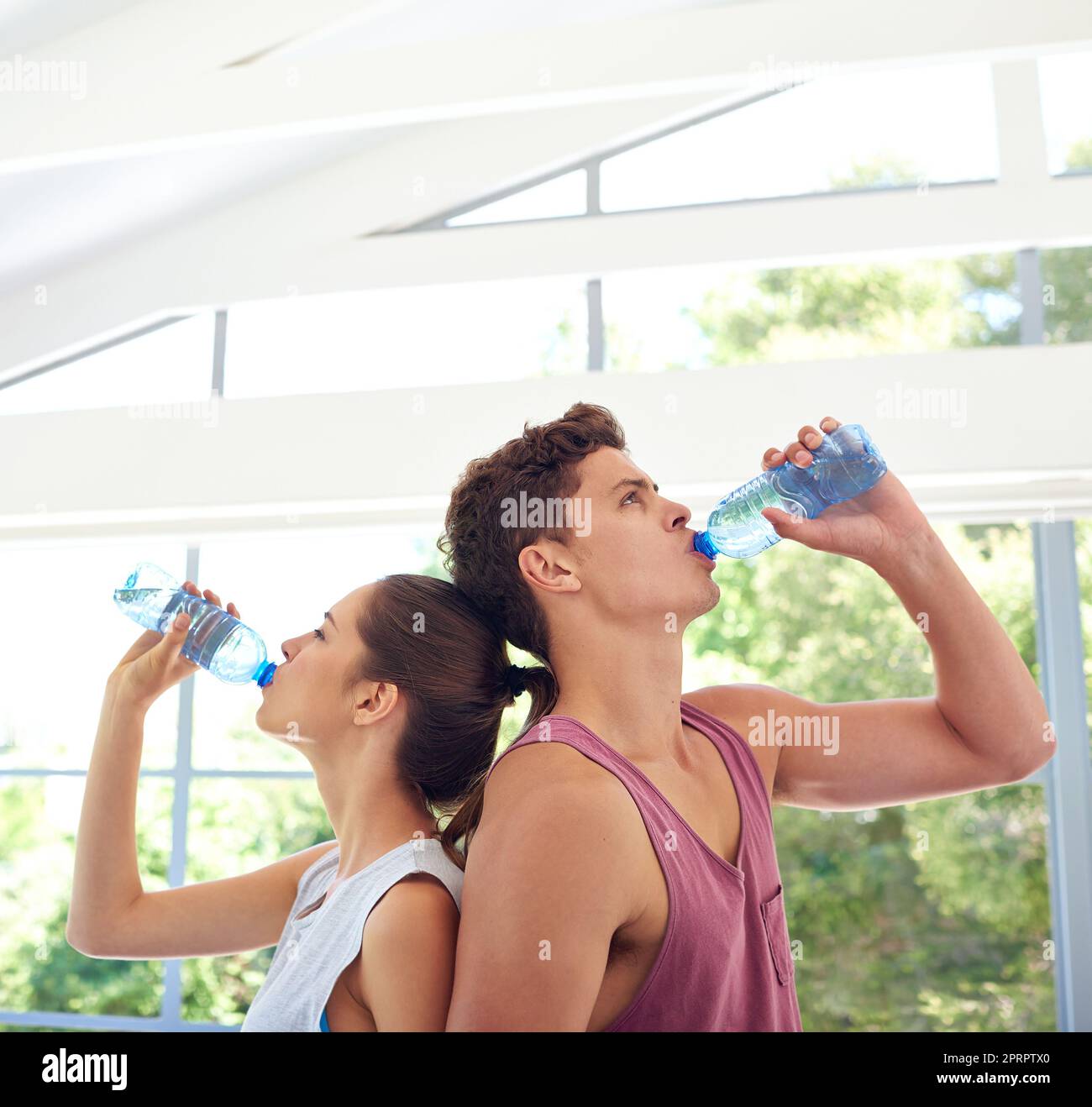 Ein junges Paar, das in Sportkleidung Rücken an Rücken steht. Stockfoto