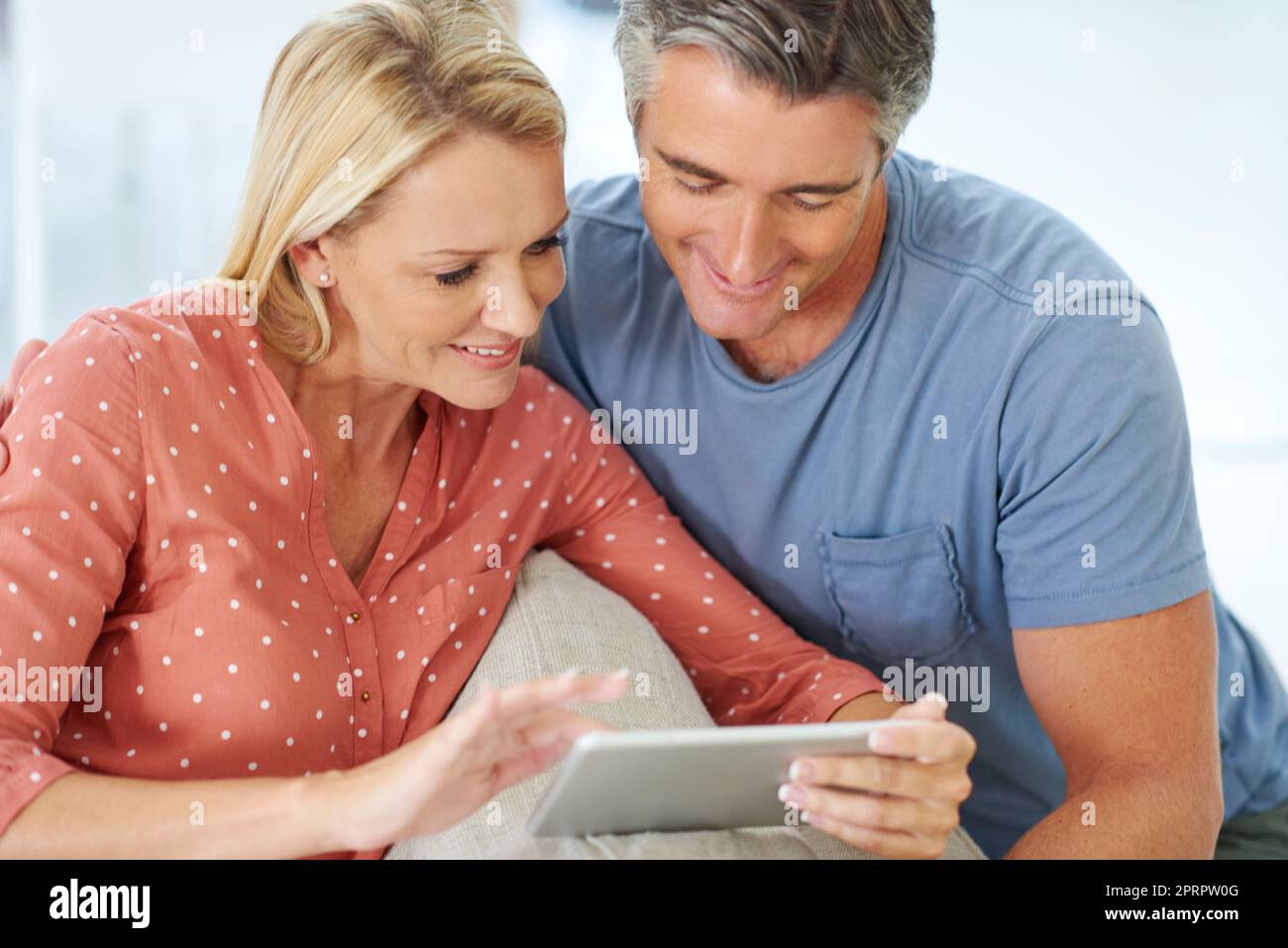 Das sieht aus wie der ideale romantische Kurzurlaub. Ein reifes Paar entspannen mit ihrem digitalen Tablet zu Hause. Stockfoto