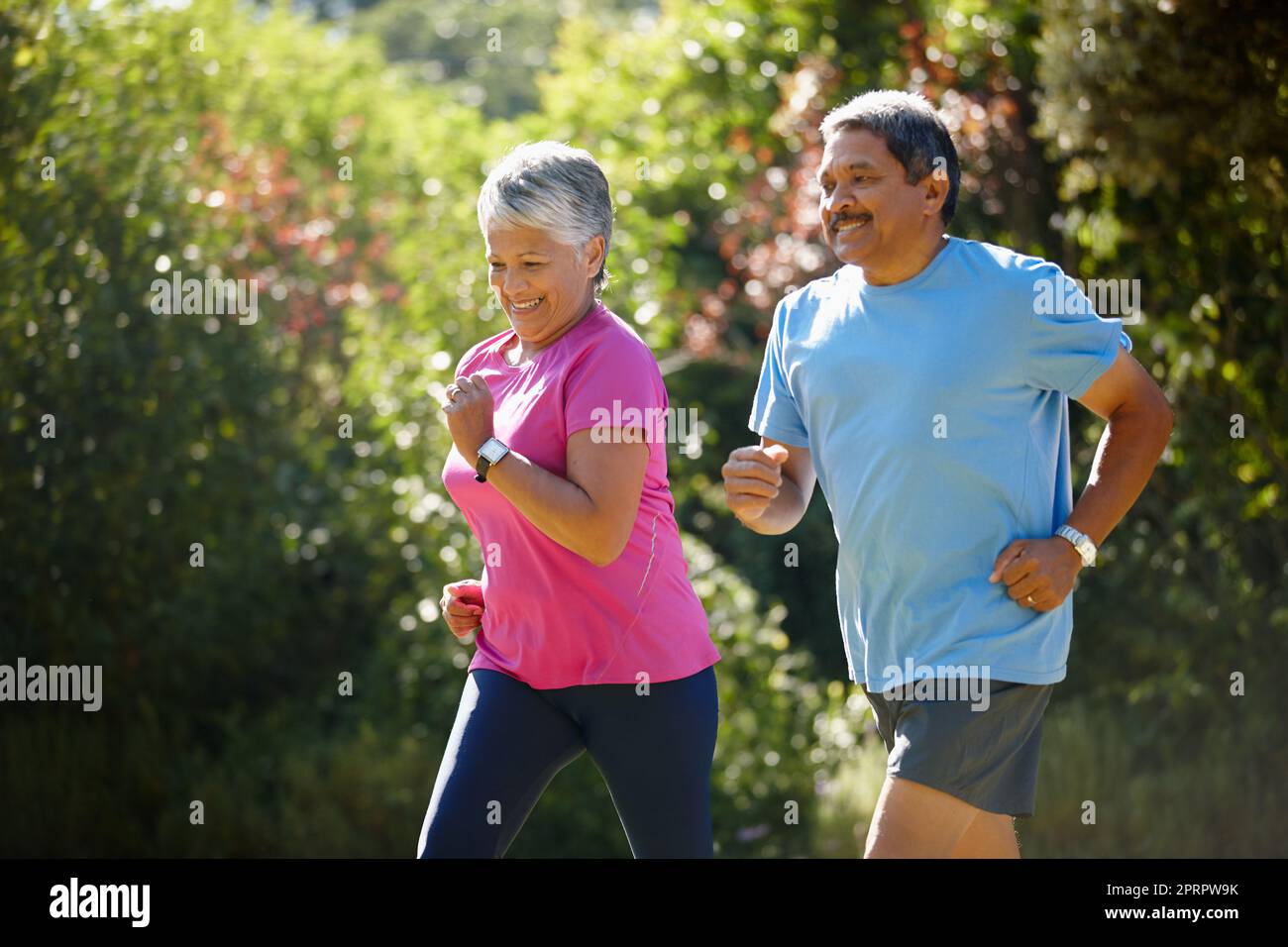 Sie sind ein aktives Paar. Ein reifes Paar, das an einem sonnigen Tag zusammen joggt. Stockfoto