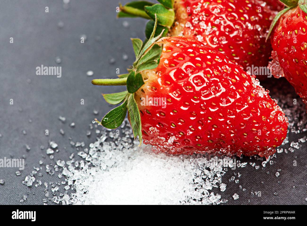 Die Farbe der Liebe. Erdbeeren und Zucker auf einer Arbeitsplatte. Stockfoto