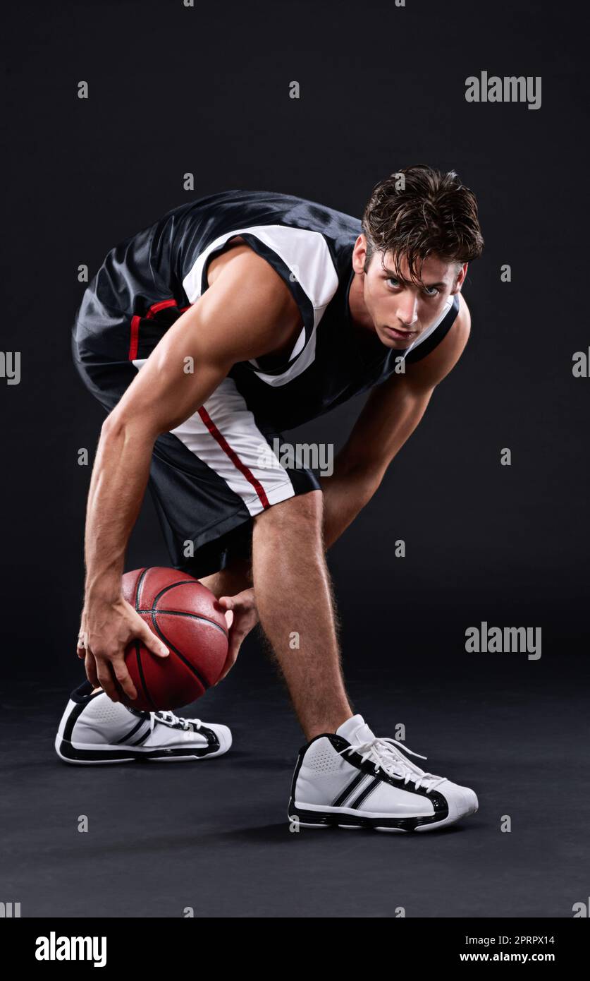 Hart trainieren, um die Besten zu sein. In voller Länge Porträt eines männlichen Basketballspielers in Aktion vor einem schwarzen Hintergrund. Stockfoto