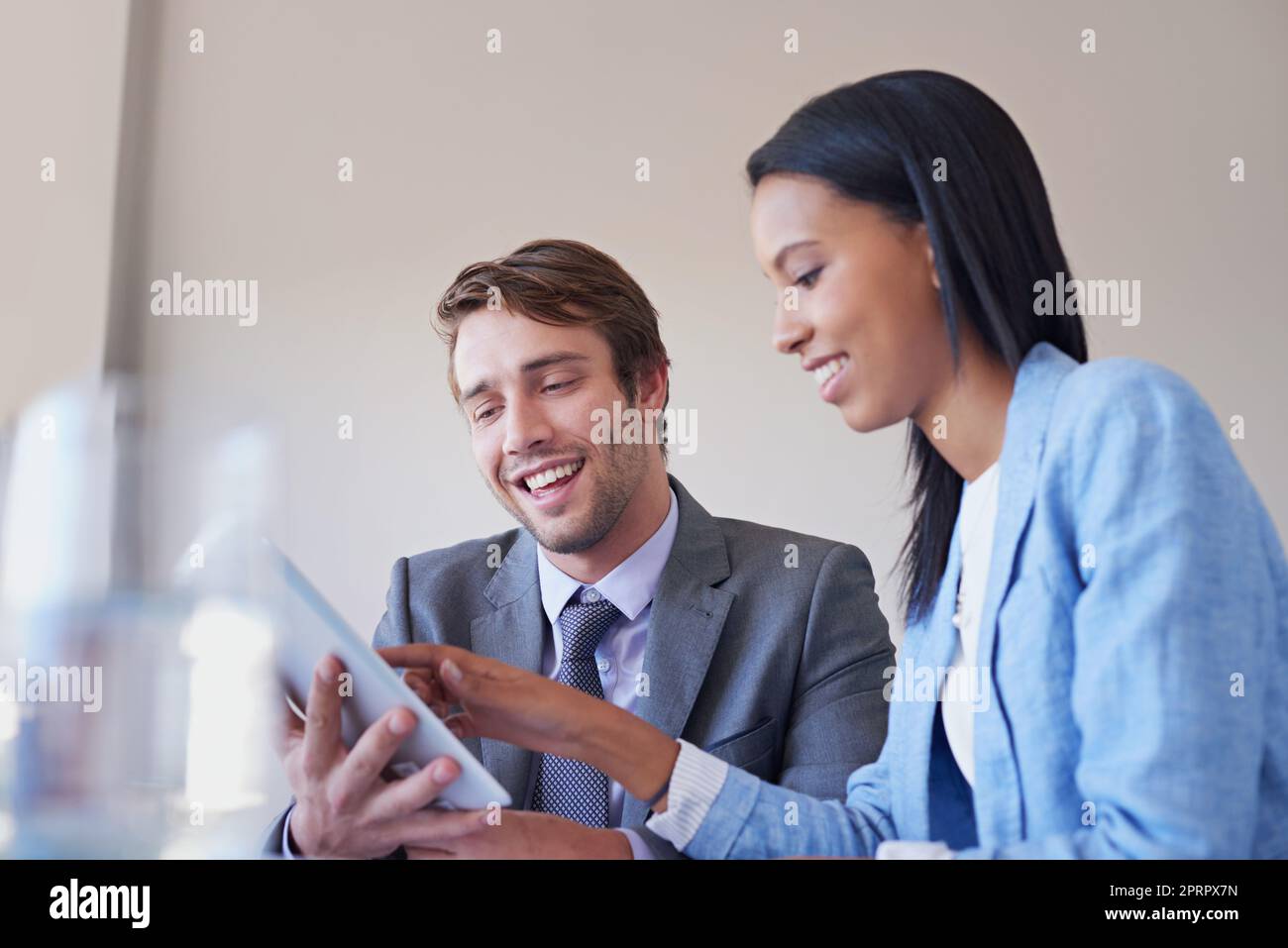 Das sieht vielversprechend aus...zwei Führungskräfte diskutieren über die Arbeit an einem digitalen Tablet. Stockfoto