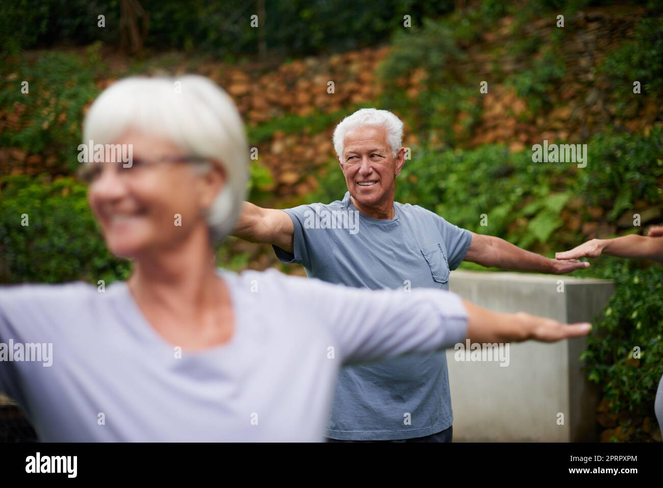 Ein älterer Mann, der einen Yoga-Kurs im Freien genießt. Stockfoto
