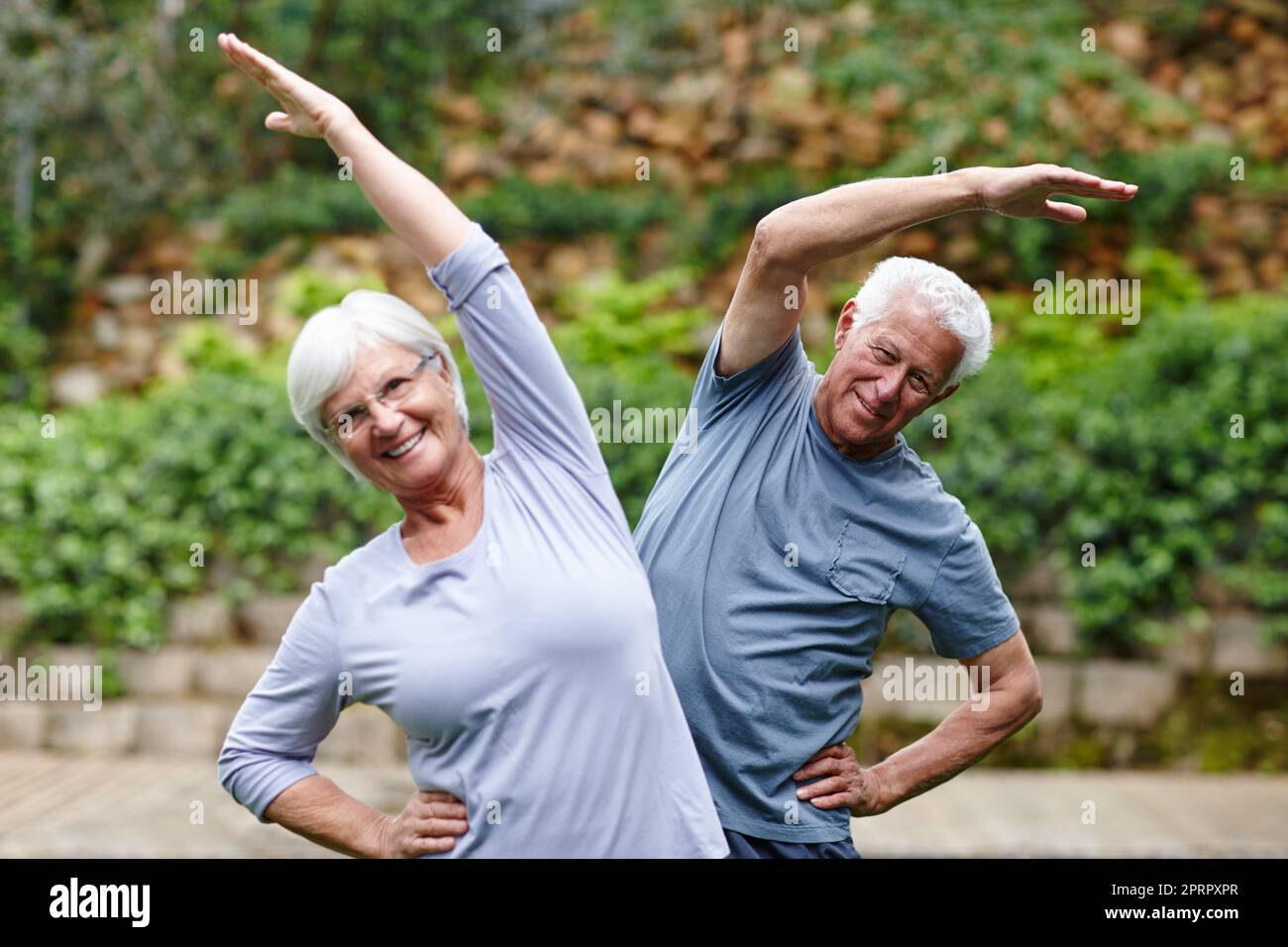Senioren bleiben aktiv. Ein Seniorenpaar macht gemeinsam Yoga im Freien. Stockfoto