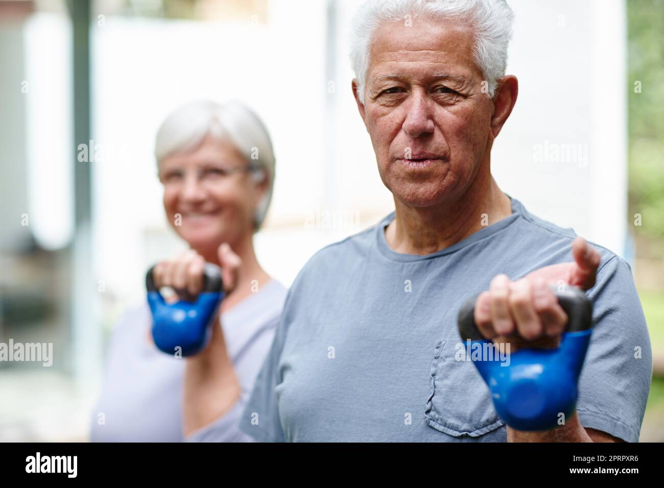 Krafttraining für Senioren. Ein Seniorenpaar Training mit leichten Gewichten im Freien. Stockfoto