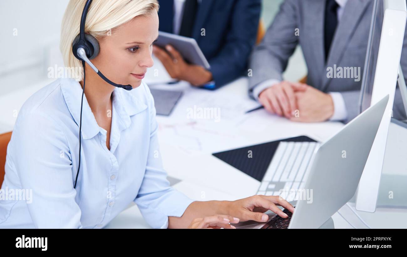 Eine Geschäftsfrau, die in einem gemeinsamen Büro an ihrem Laptop arbeitet. Stockfoto