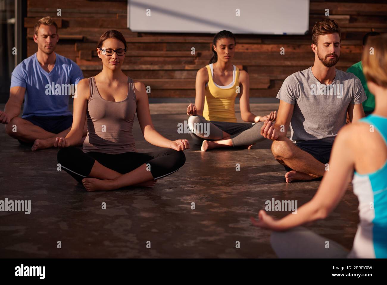 Ruhe den Geist und die Seele spricht. Eine Yogalehrerin unterweist ihre Klasse. Stockfoto