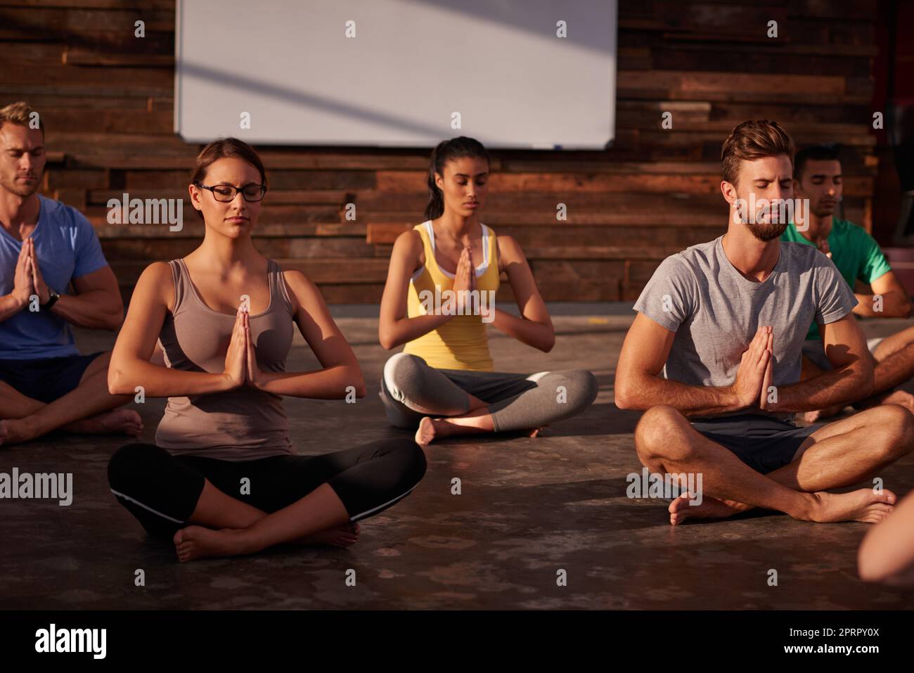 Selbstständigkeit erobert jede Schwierigkeit. Eine Gruppe von Menschen, die zusammen Yoga machen. Stockfoto