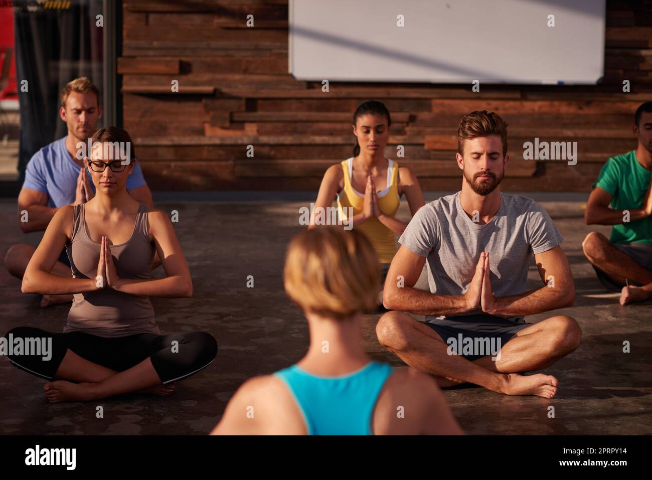Yoga ist die Antwort. Eine Yogalehrerin unterweist ihre Klasse. Stockfoto