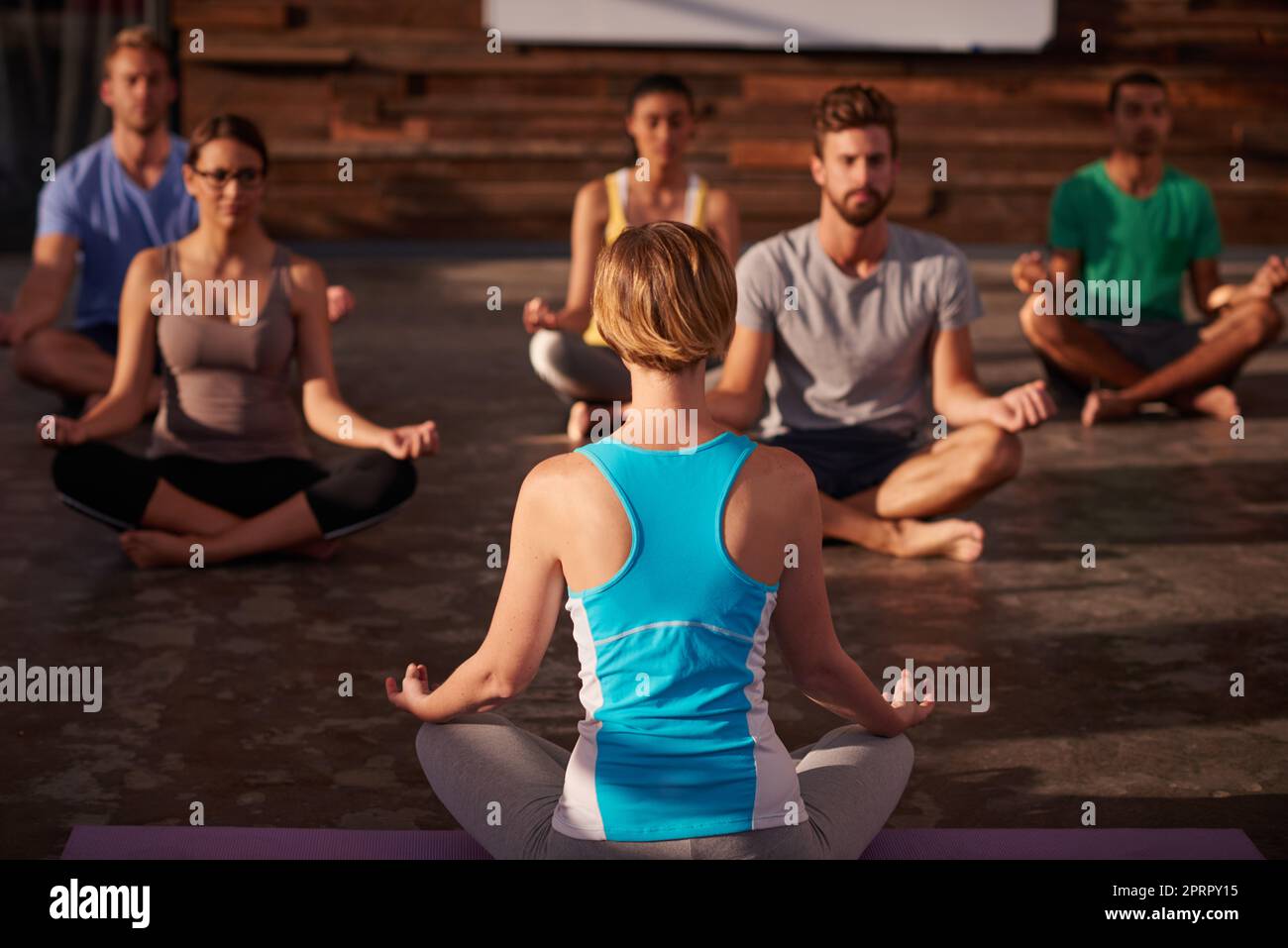 Stressfreie Zone. Eine Yogalehrerin unterweist ihre Klasse. Stockfoto
