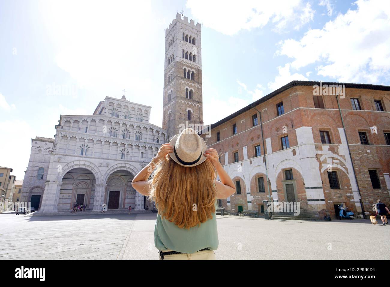 Tourismus in der Toskana. Rückansicht einer jungen Touristenfrau, die die Kathedrale von Lucca, Toskana, Italien besucht. Stockfoto
