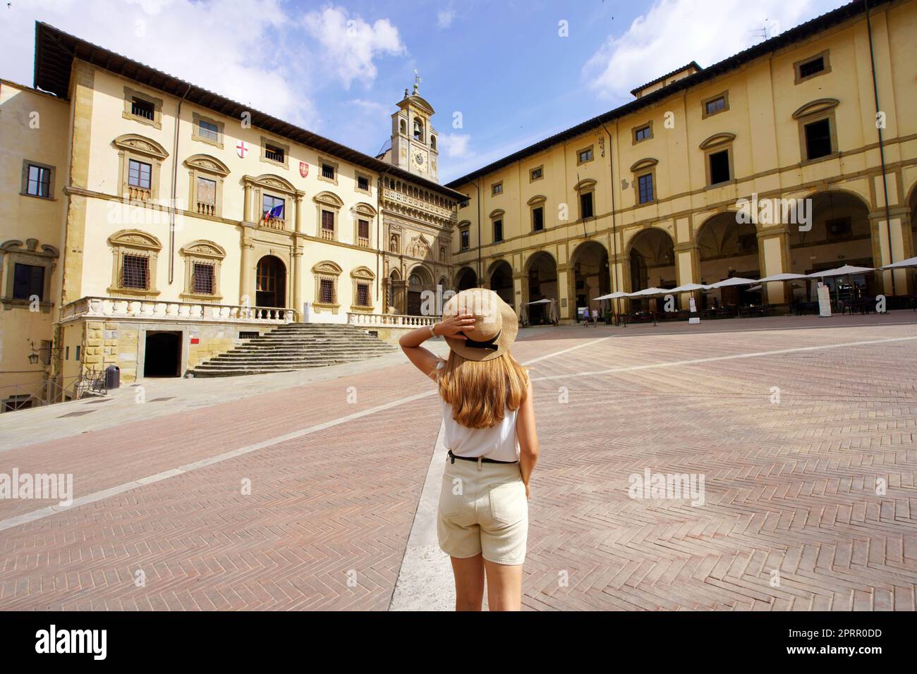 Tourismus in der Toskana. Rückansicht der jungen Reisenden Frau mit Hut auf dem Piazza Grande Platz in der Altstadt von Arezzo, Toskana, Italien. Stockfoto