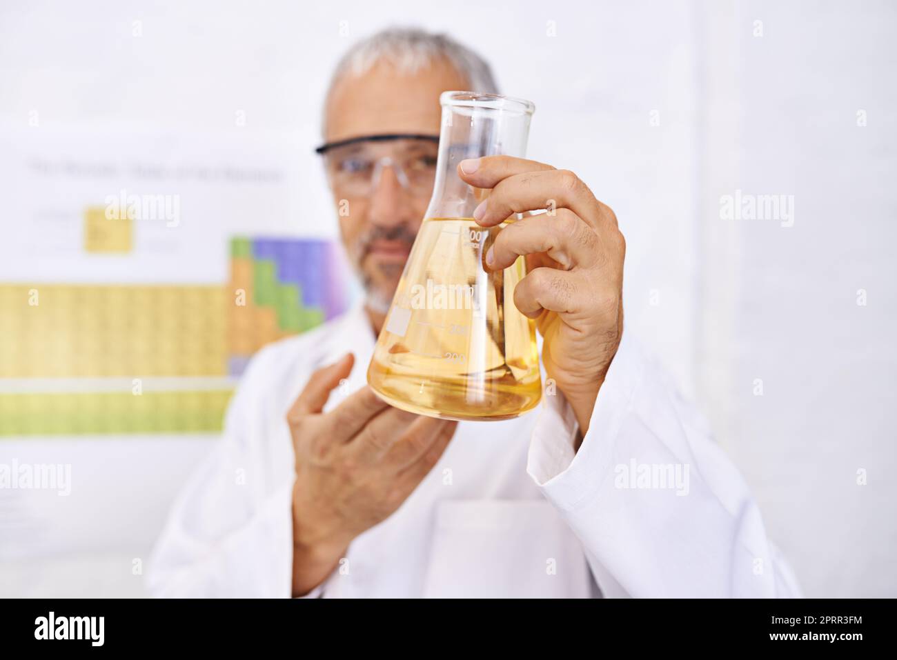 Ein reifer Wissenschaftler, der die Ergebnisse seines Chemieexperiments untersucht. Stockfoto