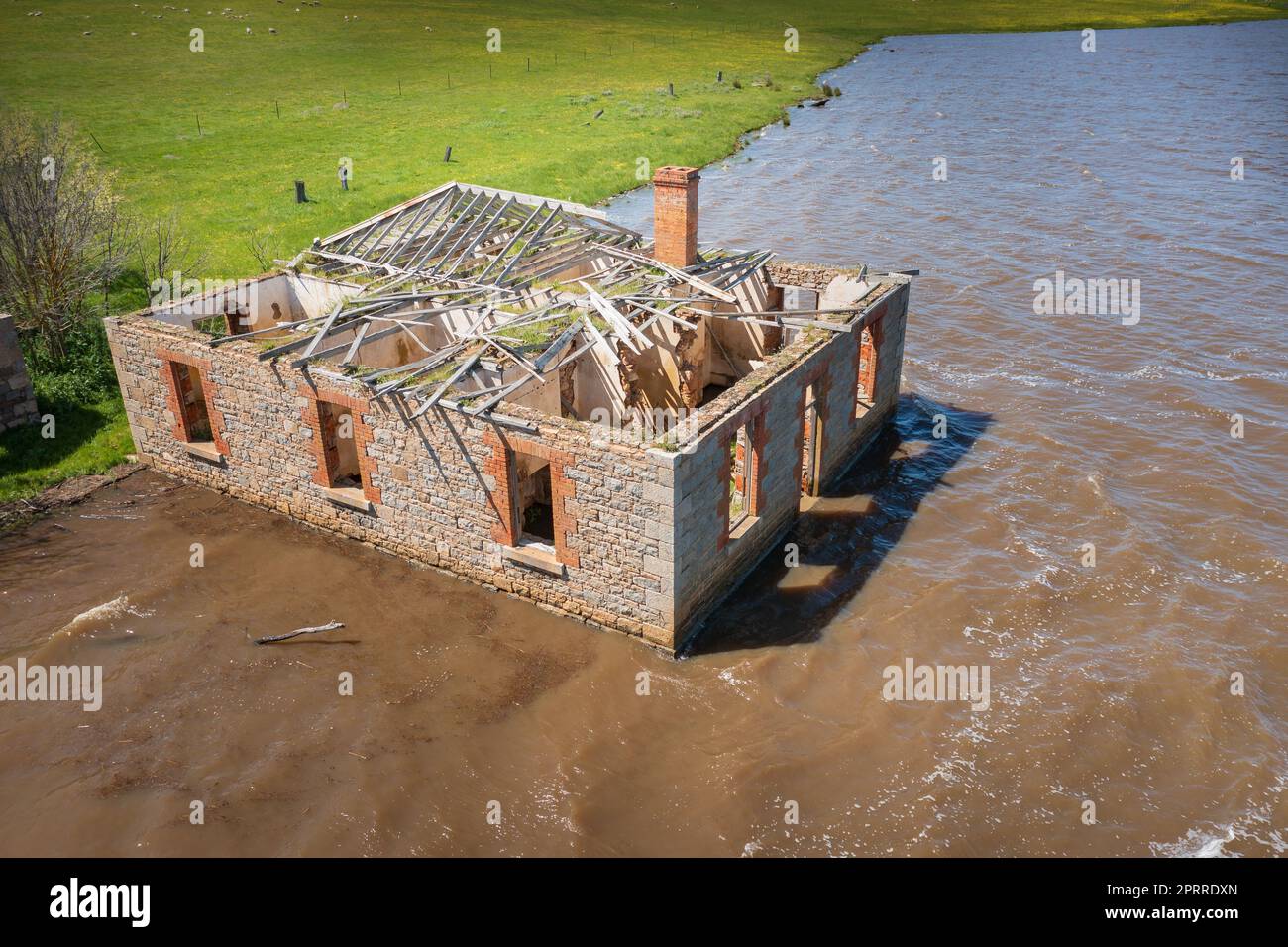 Das Cairn Curran Reservoir in Victoria, Australien, ist ein historisches Bauernhaus aus Blustein, das teilweise in einem überfluteten See liegt Stockfoto