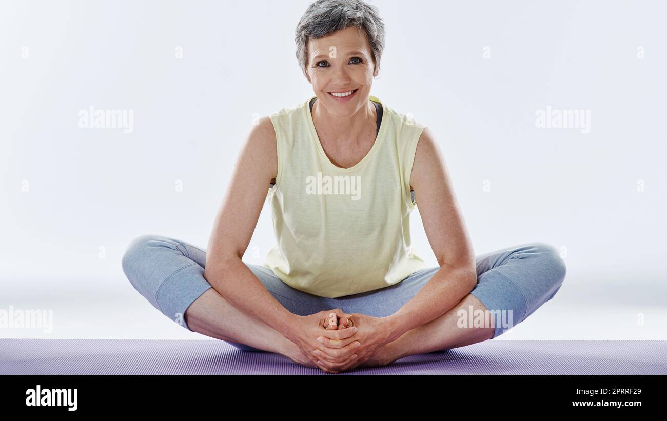 Ich mache meine Dehnübungen vor dem Workout. Ganzkörperportrait einer attraktiven Frau, die sich vor dem Yoga dehnt. Stockfoto