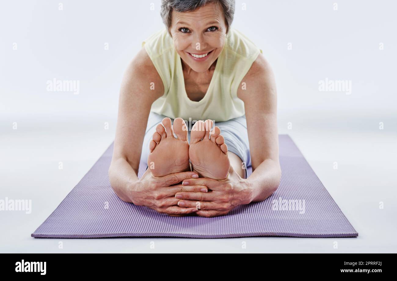 Ich liebe es zu arbeiten. Ganzkörperportrait einer attraktiven Frau, die sich vor dem Yoga dehnt. Stockfoto