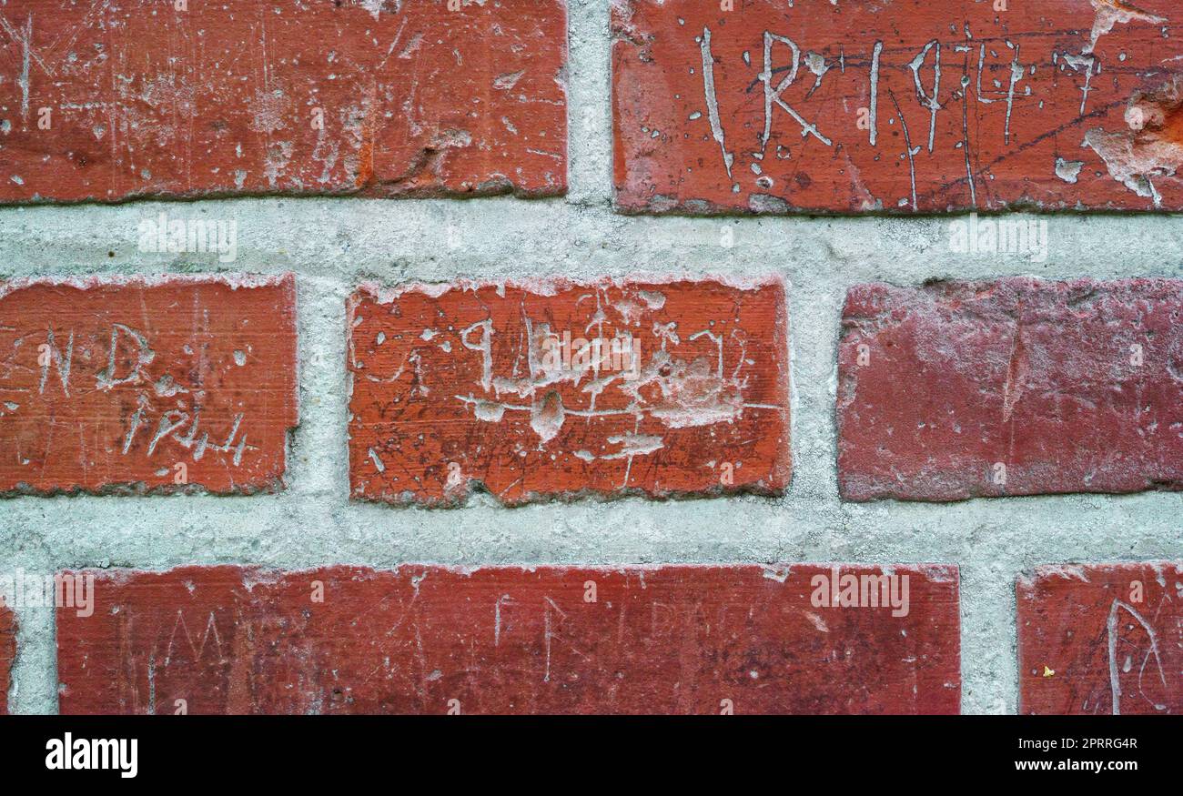 Charakteristische Wand. Ein Foto einer alten Schule mit einer Ziegelwand mit Unterschriftenlisten von Schulkindern, die über einen Zeitraum von mehr als 120 Jahr geschrieben wurden. Alte Graffiti Dänemark. Stockfoto