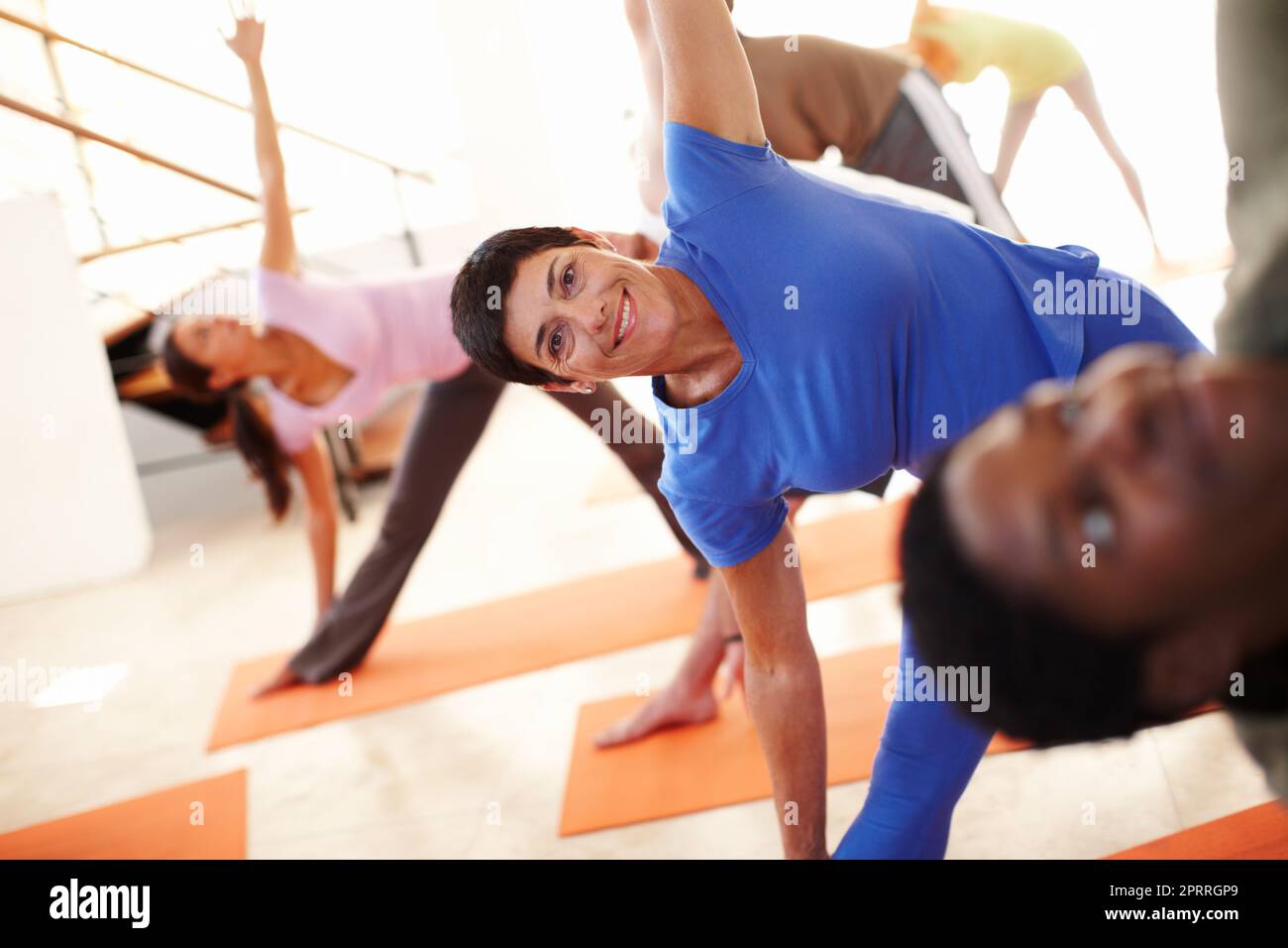 Yoga hält sie geschmeidig. Eine Frau mittleren Alters, die während eines Yoga-Kurses Yoga-Übungen macht. Stockfoto