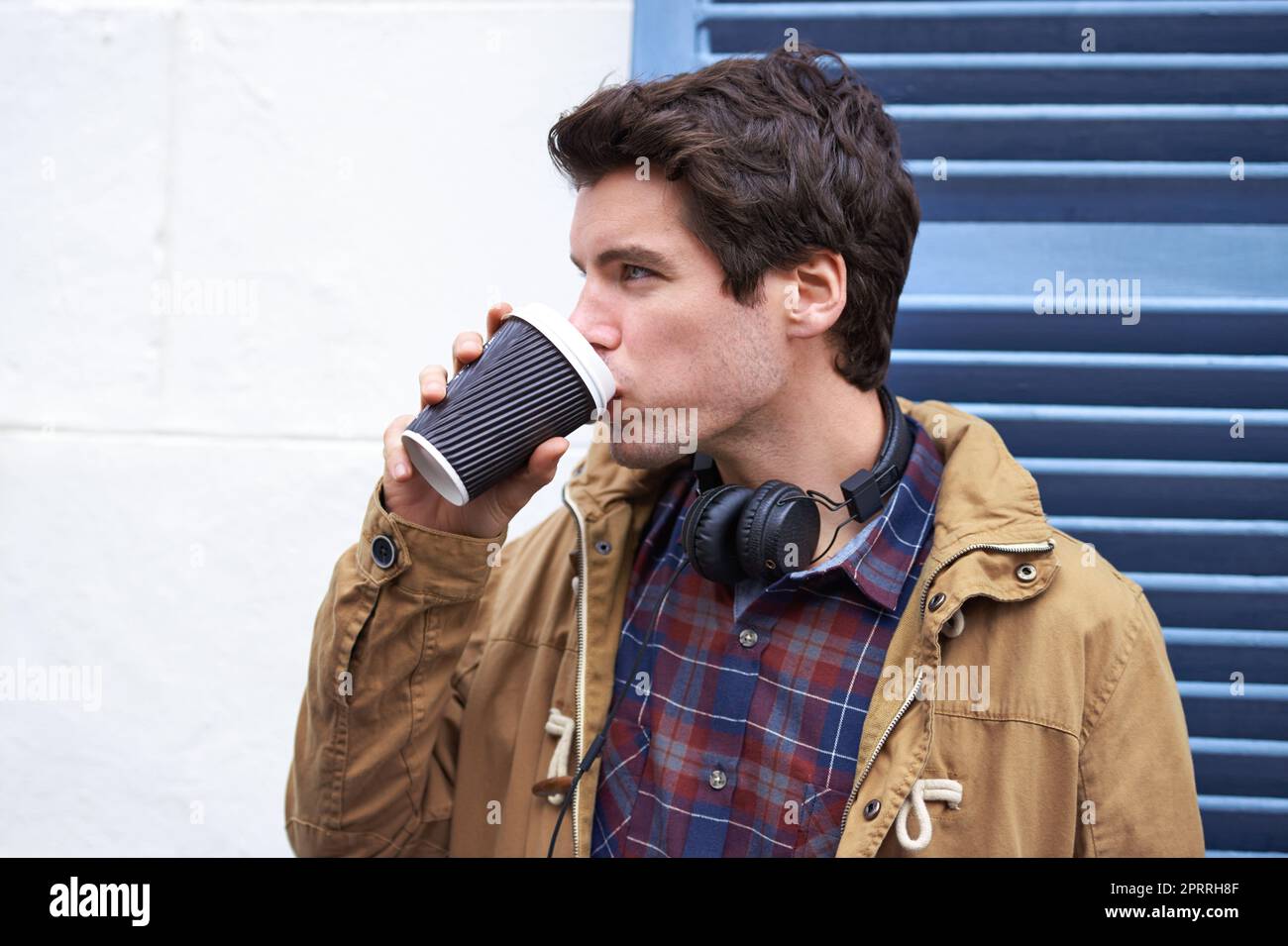 Unterwegs, in der Innenstadt. Ein hübscher junger Mann, der in einem Stadtbezirk chillt. Stockfoto