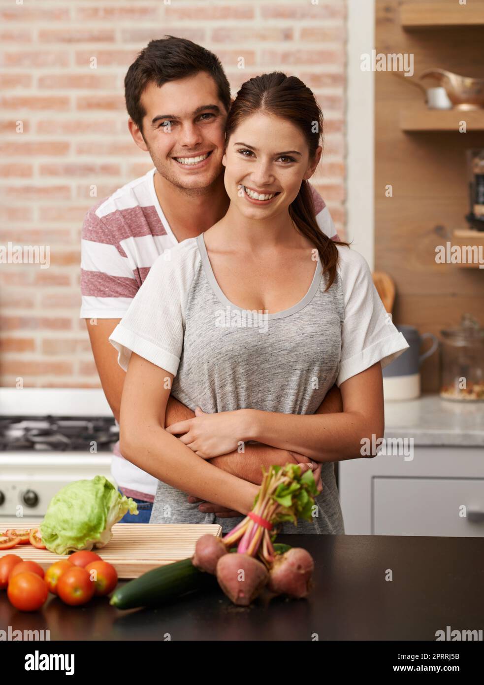 Kochen mit Liebe. Porträt eines attraktiven jungen Paares, das sich in der Küche verklebt. Stockfoto