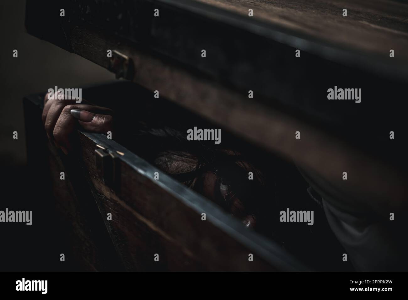 Asiatischer Geisterhorror gruseliges Haar, das Gesicht und Auge in der alten Schatztruhe verdeckt Stockfoto