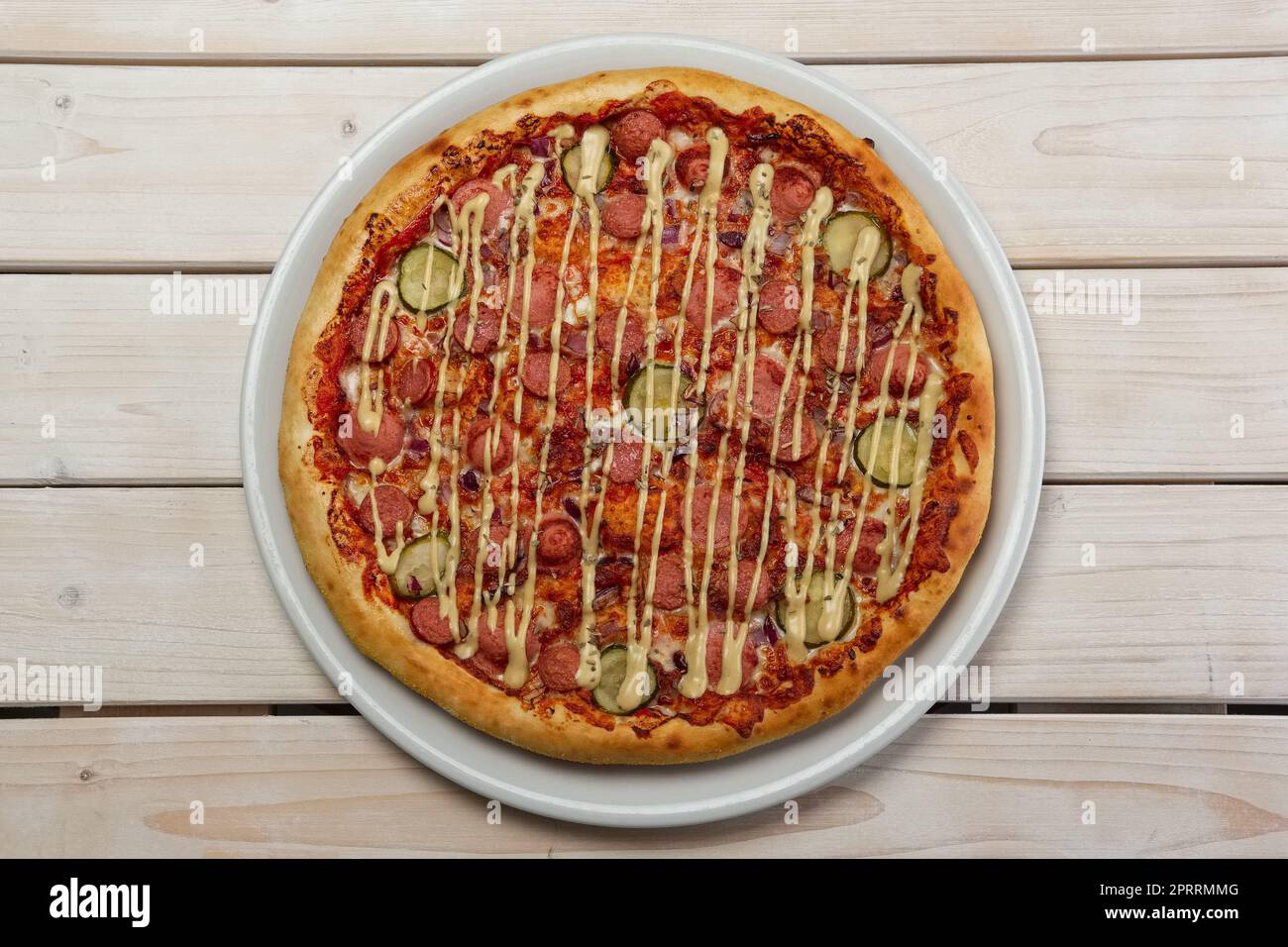 Blick von oben auf die Pizza mit Wurst und Gurken Stockfoto