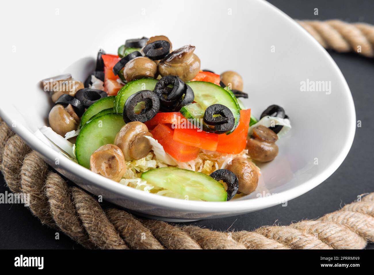 Closeup-Teller mit Salat mit Champignons, Oliven, Gurken und Paprika Stockfoto